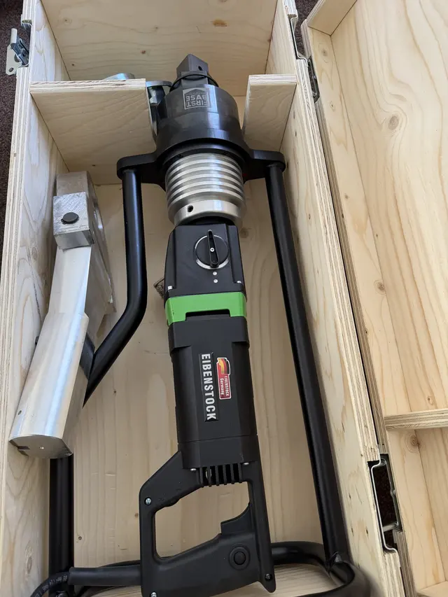 Hilti-branded electric tool and separate metal attachment photographed in a timber transport case.